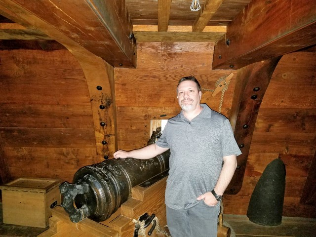Adam with one of the cannons in the replica of the interior of the ship